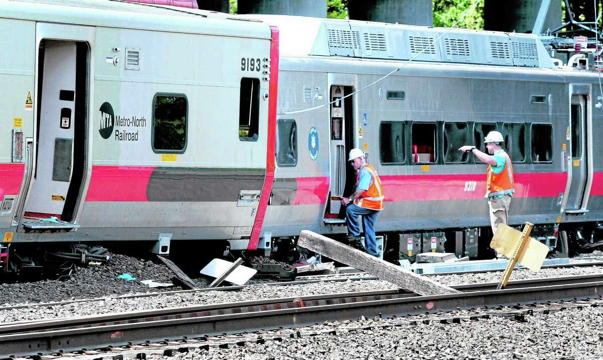 Investigators enter the northbound Metro North train involved in a derailment in Bridgeport near the Fairfield line on 5/18/2013. At left is the southbound train involved in the accident. ¬ Photo by Arnold Gold/New Haven Register
