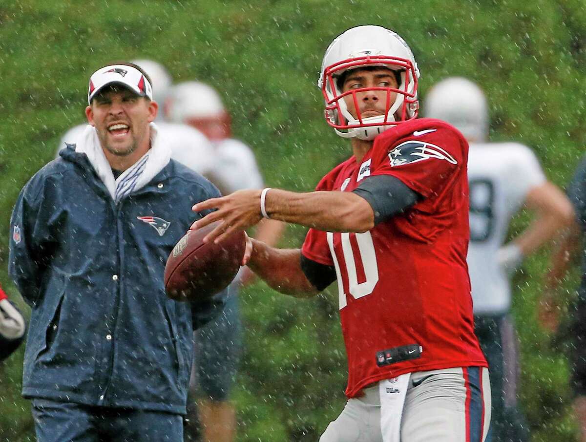 New England Patriots quarterback Jimmy Garoppolo passes while offensive coordinator Josh McDaniels watches during an August practice.