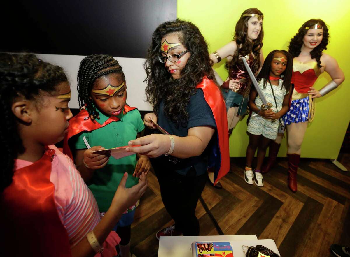 Carmen Ford, 10, left, Don Coleman, 10, and Karen Lopez, 17, third from left, look at their photos as Zoe Mayes, 9, in background, has her photo taken during a Wonder Woman Bowling Party for 30 area girls ages 7 to 12 held at Bowlmor, 925 Bunker Hill Road, hosted by Joy Sewing, Houston Chronicle Fashion and Beauty Editor, as part of her #YearOfJoy project Monday, July 24, 2017, in Houston.