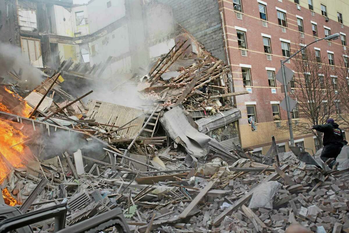 Emergency workers respond to the scene of an explosion and building collapse in the East Harlem neighborhood of New York, Wednesday, March 12, 2014. The explosion leveled an apartment building, and sent flames and billowing black smoke above the skyline. (AP Photo/Jeremy Sailing)
