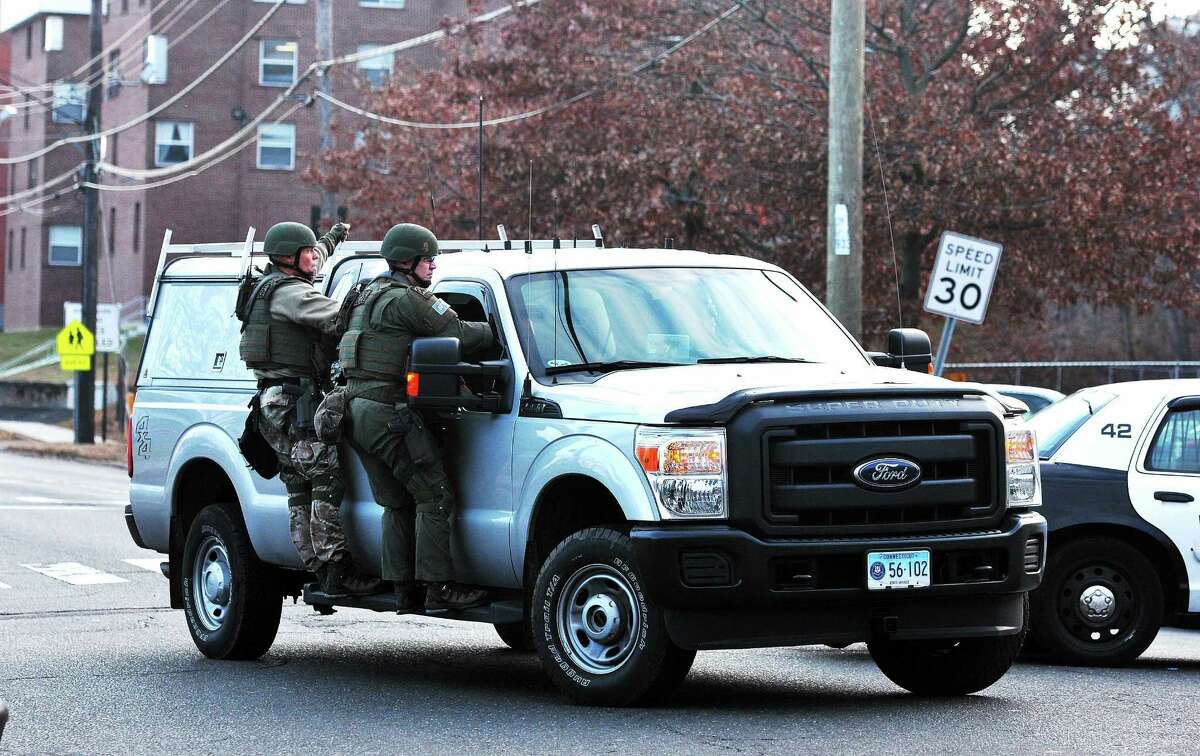 State Police SWAT troopers ride a truck along Campbell Avenue in West Haven after a report of a person with a gun caused a lockdown of UNH and surrounding buildings and streets Dec. 3, 2013.