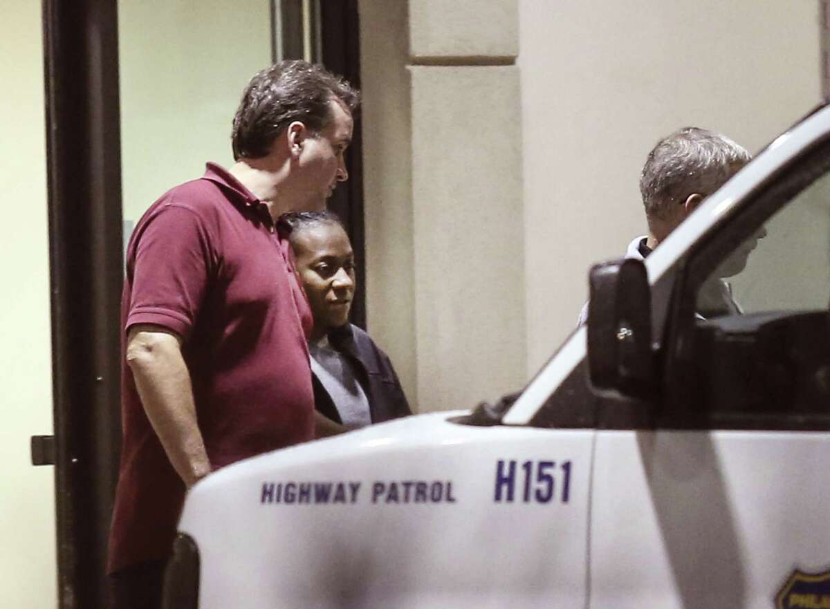 Carlesha Freeland-Gaither, second from left, is escorted from Howard County General Hospital in Columbia, Md. early Thursday morning, Nov. 6, 2014, by Philadelphia Detectives James Sloan, left, and John Geliebter, right, partially obscured. Freeland-Gaither was abducted off the streets of Philadelphia Sunday night night. Law enforcement agents rescued her Wednesday outside Baltimore and arrested suspect Delvin Barnes.