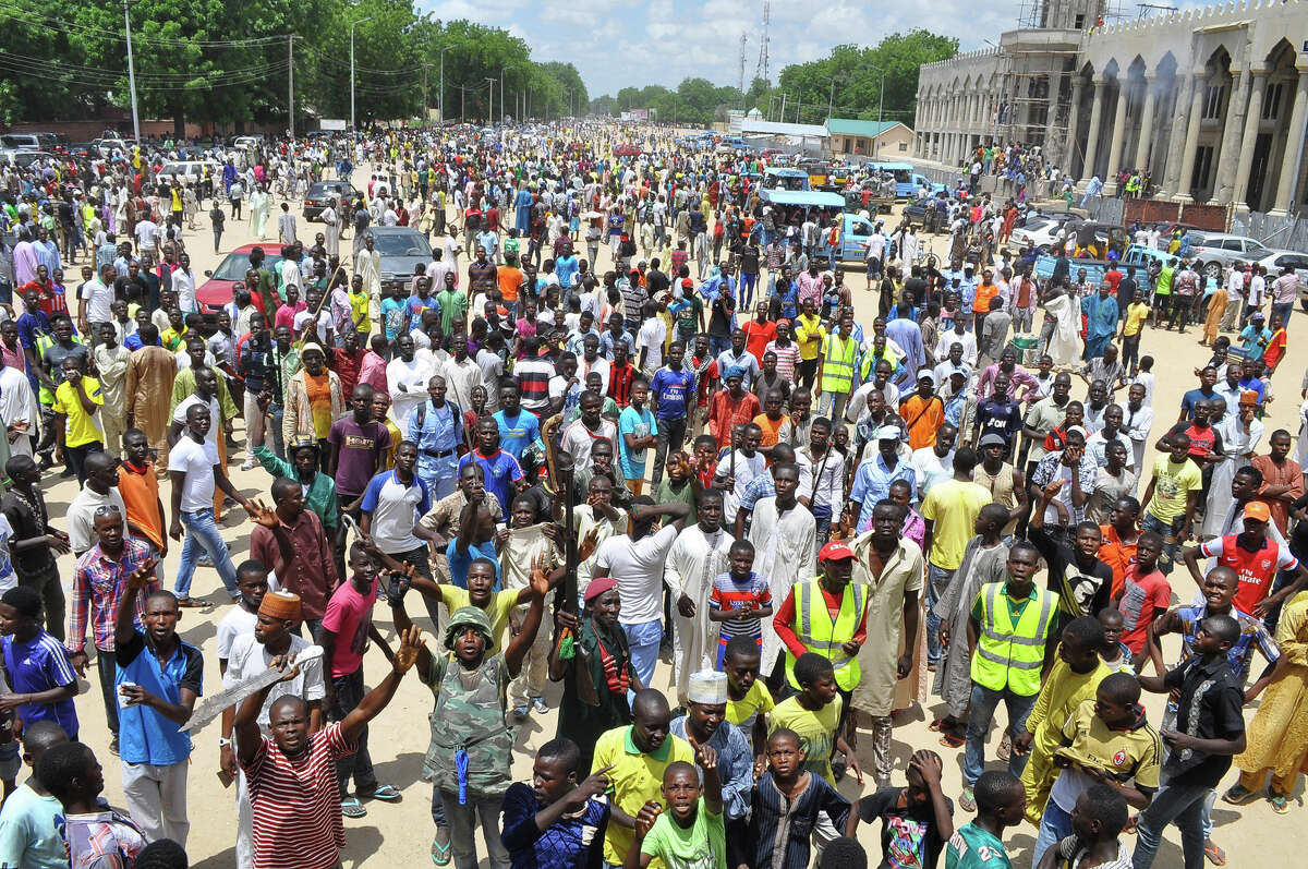 Vigilantes and local hunters armed with machetes and guns shout slogans as they gather outside the Emir's palace in Maiduguri, Nigeria, Thursday, Sept. 4, 2014. The United States is preparing to launch a "major" border security program to help Nigeria and its neighbors combat the increasing number and scope of attacks by Islamic extremists, a senior U.S. official for Africa said Thursday. (AP Photo/Jossy Ola)