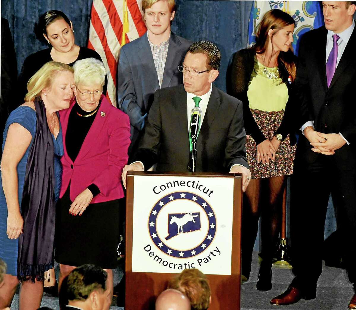 Incumbent Connecticut Gov. Malloy with Lt. Gov. Nancy Wyman, and Malloy’s wife Cathy, far left, leaning on Wyman, gives a post-midnight speech to supporters claiming victory on election night at The Society Room in Hartford, Connecticut during a close race against Republican challenger Tom Foley Tuesday, November 4, 2014.