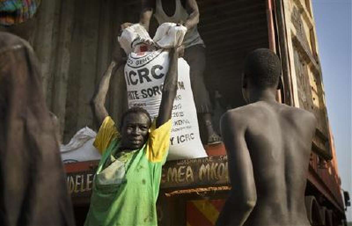 A man unloads food assistance supplied by the international Red Cross that arrived by boat and then truck in the town of Awerial, South Sudan.