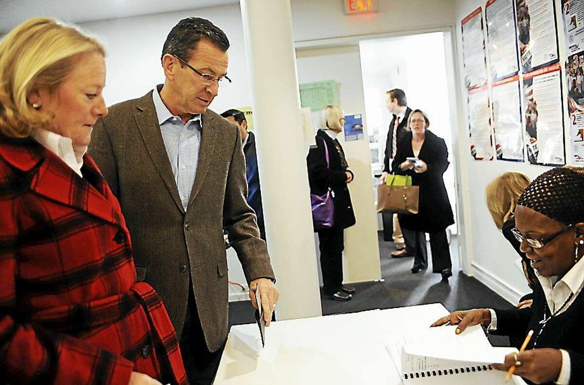 Gov. Dannel P. Malloy, center and wife Cathy, left, check in to vote Tuesday in Hartford. Malloy is facing Republican candidate Tom Foley in today’s election.