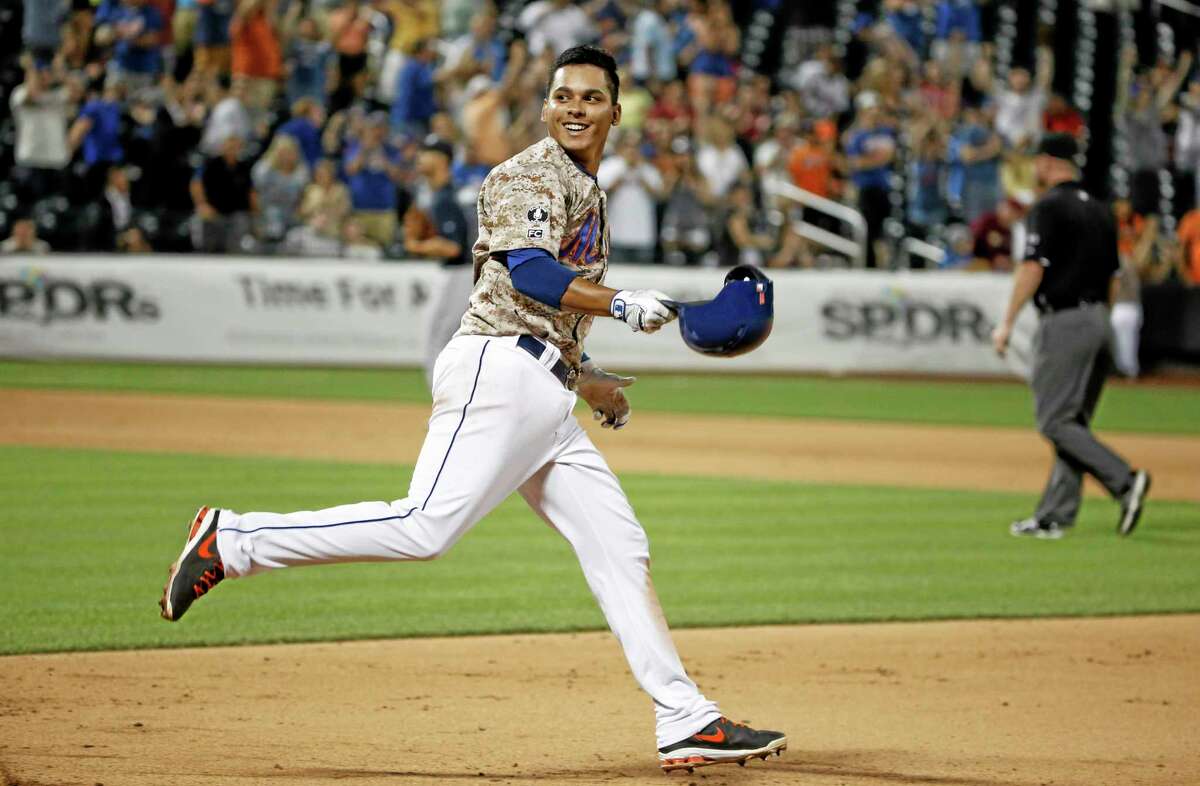 The Mets’ Ruben Tejada (11) smiles as he looks back at his teammates after hitting an 11th inning, game-winning, walk-off, RBI single in the Mets’ 4-3 victory over the Atlanta Braves.