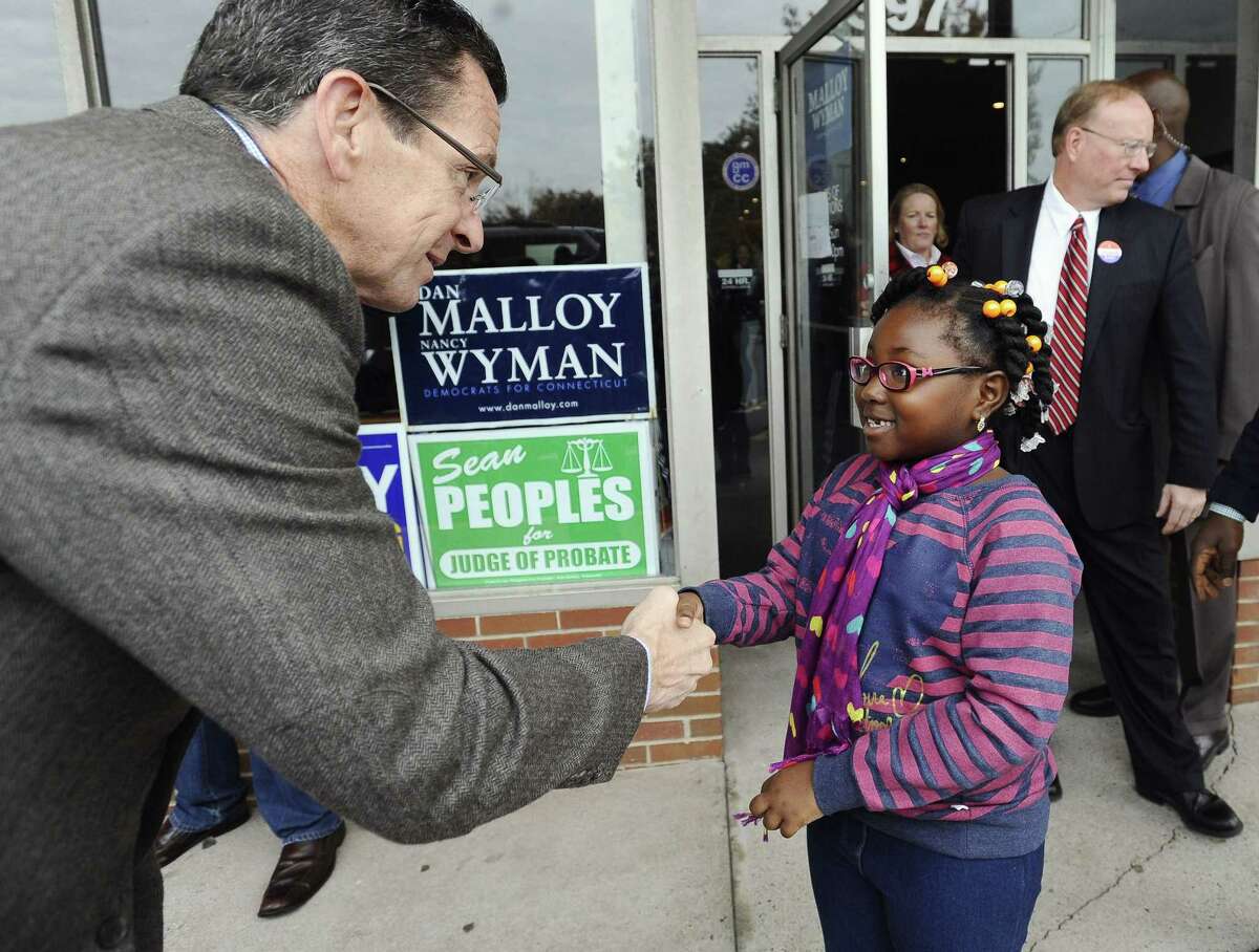 Connecticut Gov. Dannel P. Malloy greets Krista Bamfo, 7, of Manchester, outside Manchester Democratic headquarters on Election Day, Tuesday, Nov. 4, 2014, in Manchester, Conn. Malloy is facing Republican candidate Tom Foley. (AP Photo/Jessica Hill)