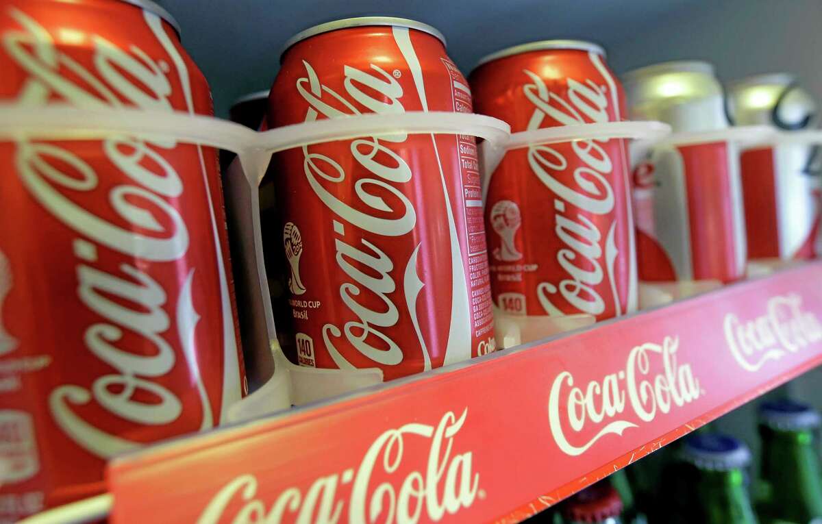 In this June 30, 2014 photo cans of Coca-Cola soda pop are shown in the refrigerator inside of Chile Lindo in San Francisco. San Francisco and Berkeley are aiming to become the first U.S. cities to pass per-ounce taxes on sugary drinks. (AP Photo/Jeff Chiu)