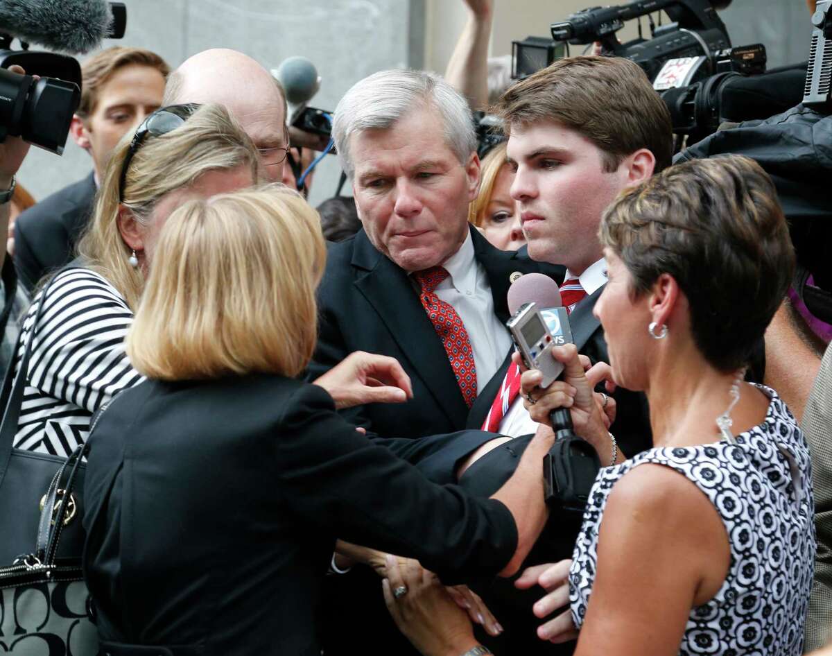 Former Virginia Gov. Bob McDonnell, center, is mobbed by media as he gets into a car with his son, Bobby, right, after he and his wife, former first lady Maureen McDonnell, were convicted on multiple counts of corruption at Federal Court in Richmond, Va., Thursday.
