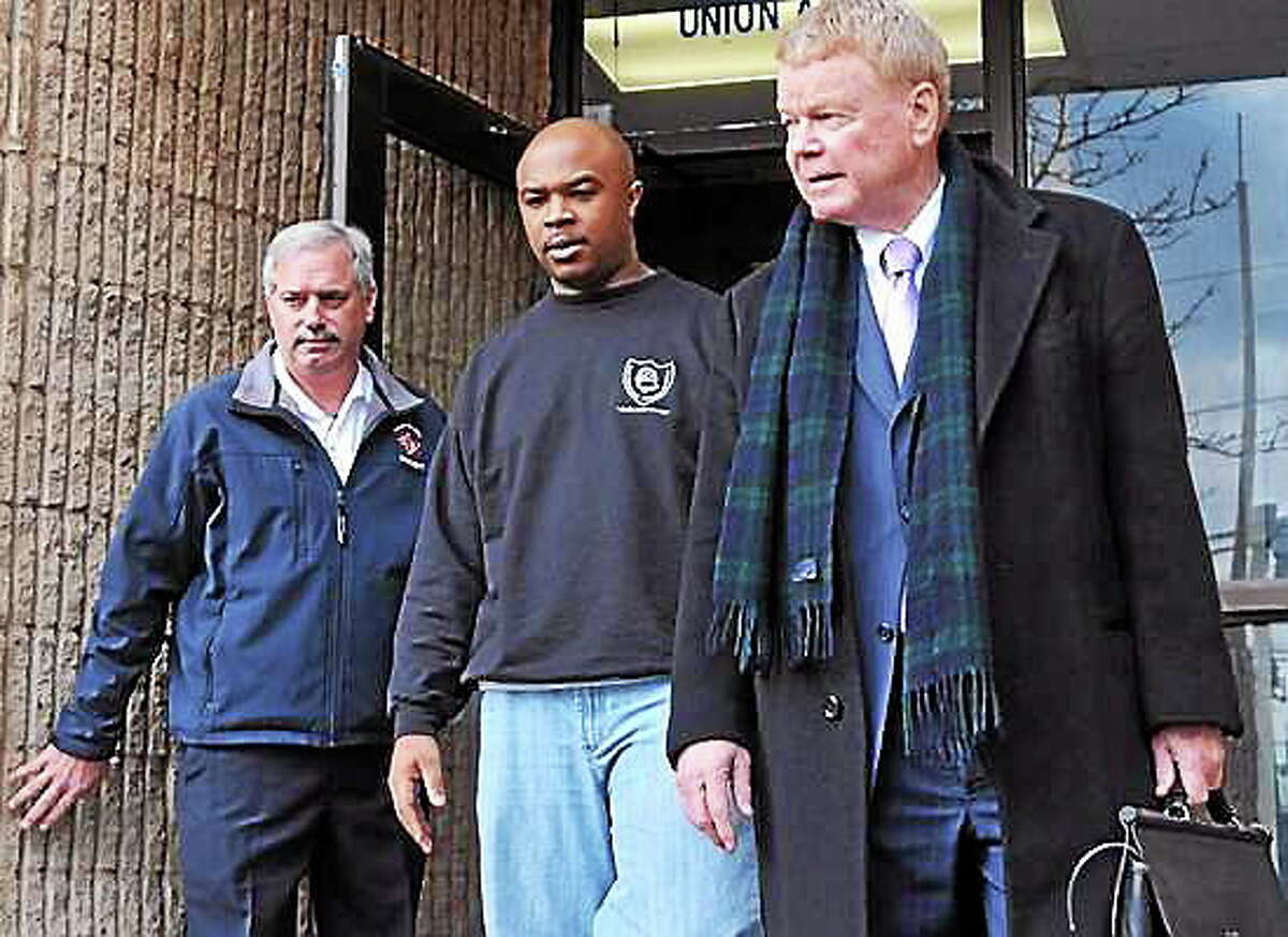 New Haven Firefighter Aaron Brantley, center, leaves police headquarters with his attorney Hugh Keefe, right, and Lt. James Kottage, fire union president.