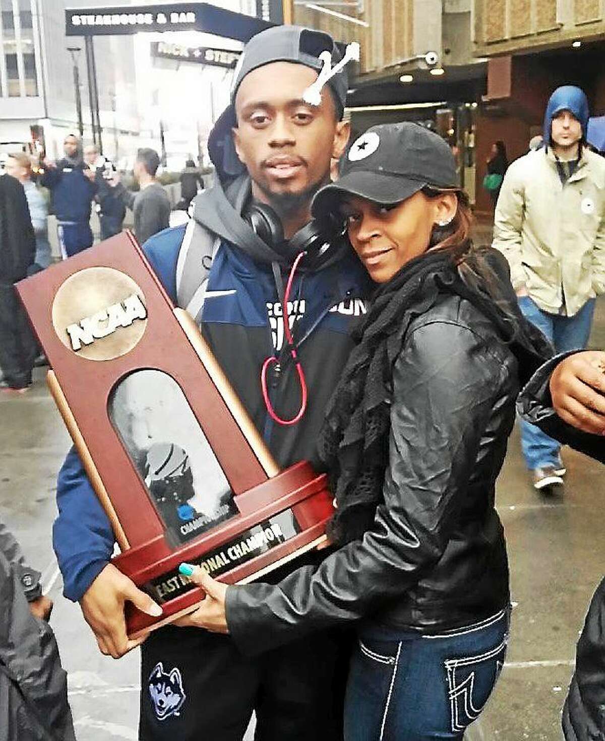 UConn senior Ryan Boatright and his mother, Tanesha, pose with the Huskies’ national championship trophy.