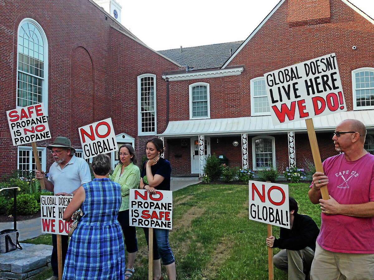 Opponents of a proposed wholesale propane distribution facility in Clinton carry signs outside Andrews Memorial Town Hall Monday.
