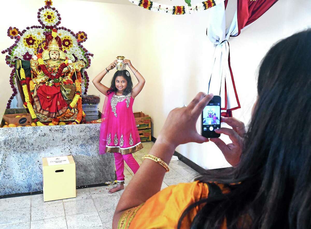 Karishma Bulsara, 8, of Bethany poses with a kalasham (urn for holy water) for a photo taken by her mother Nita.