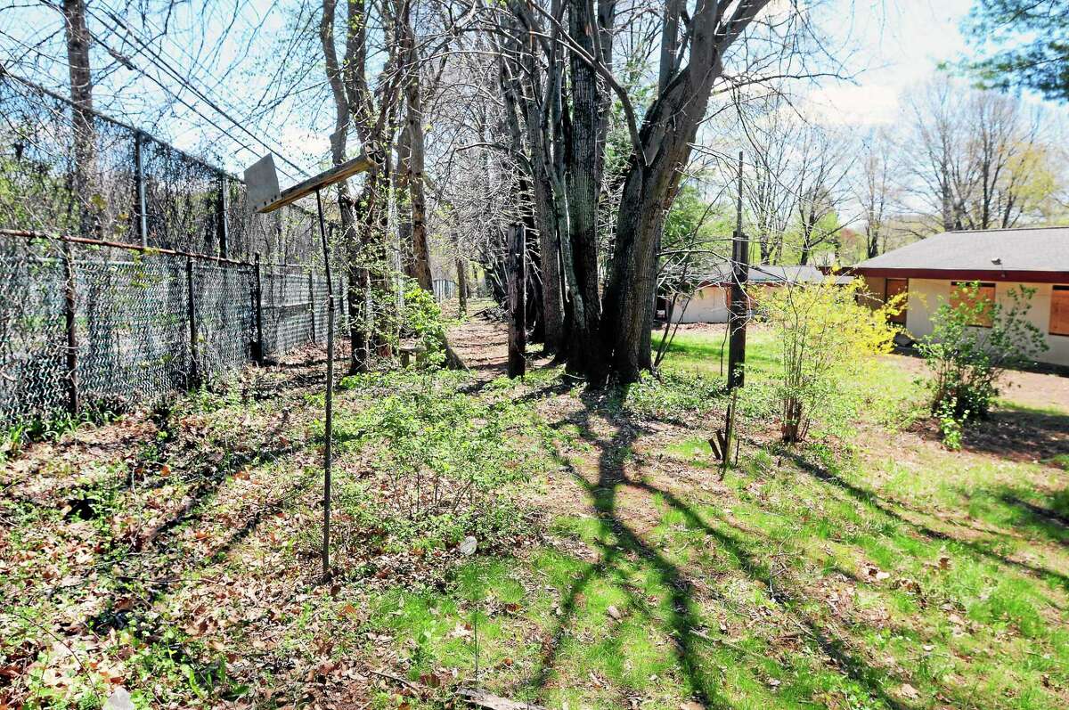 A tall fence separates the Abraham Ribicoff Cottages in New Haven and Woodin Street in Hamden.