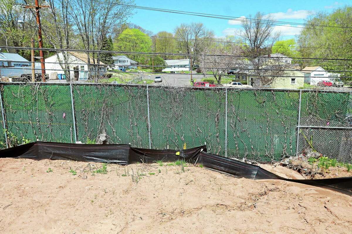 Arnold Gold — New Haven Register A tall fence separates the end of Wilmot Road in New Haven and Woodin Street in Hamden.
