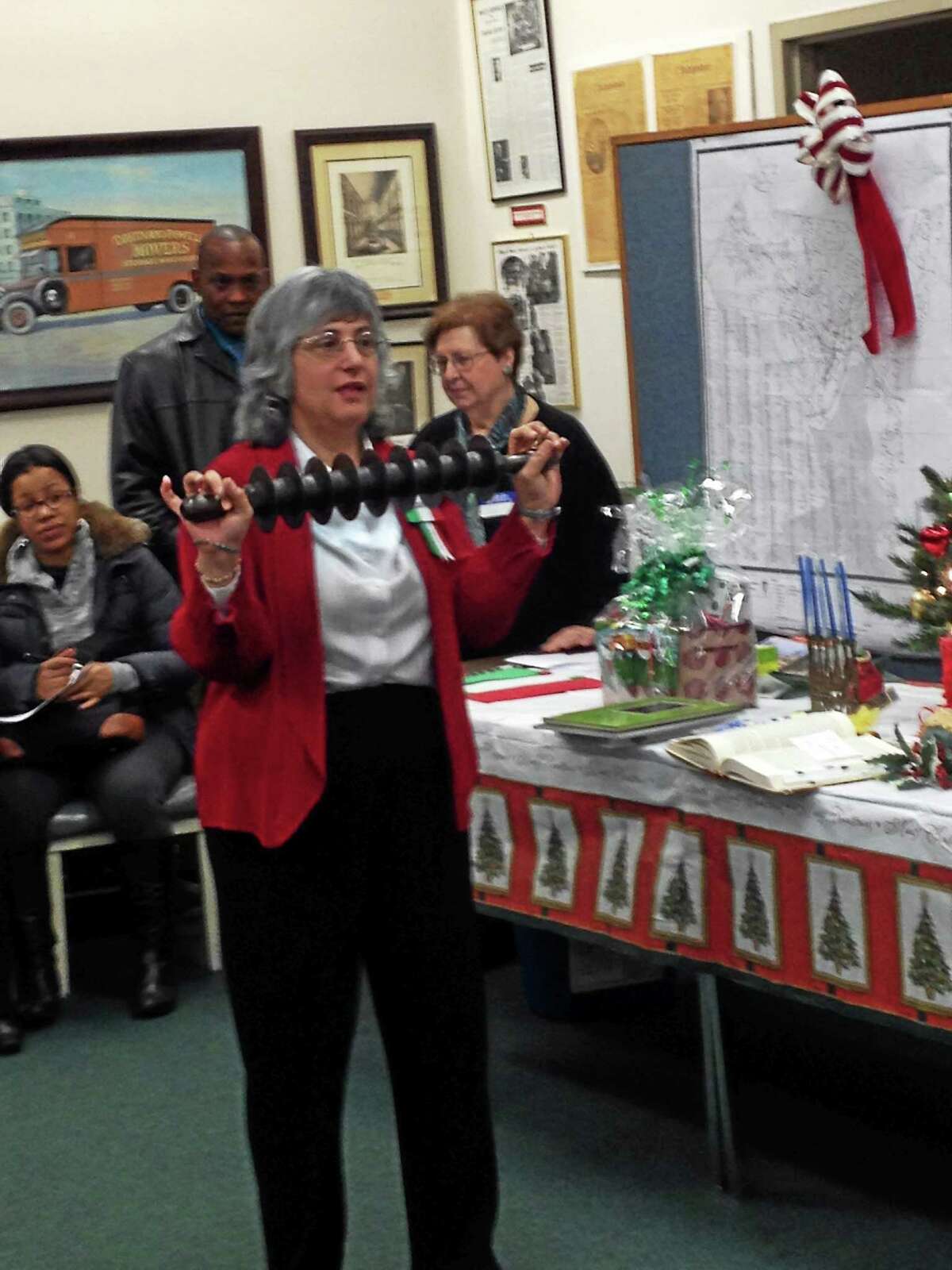Laura Parisi, president if the Italian American Heritage Society, shows a cutter from a local bakery used to make traditional sweet candy. Parisi spoke about Italian holiday traditions Sunday at New Haven’s Ethnic Heritage Center.