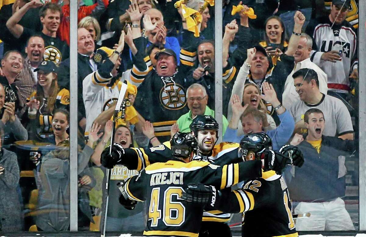 Fans cheer as Bruins left wing Milan Lucic, center, celebrates his empty-net goal with center David Krejci (46) and right wing Jarome Iginla, right, late in the third period in Game 2 of a second-round Stanley Cup series against the Montreal Canadiens on Saturday in Boston.