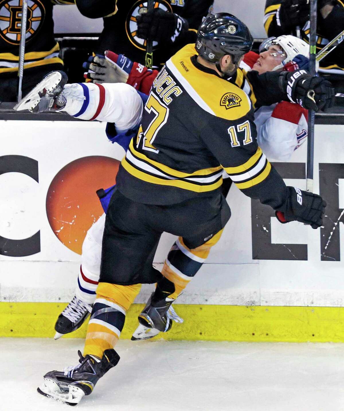 Bruins left wing Milan Lucic (17) drives Montreal Canadiens right wing Brendan Gallagher (11) into the board during the third period of Game 2 in the second-round Stanley Cup series on Saturday in Boston.