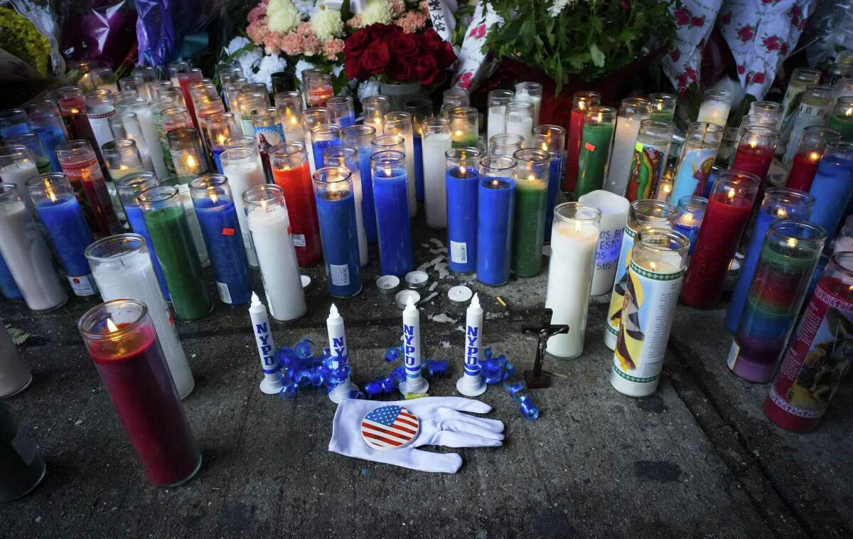 Candles and other items left by visitors make up a growing makeshift memorial Tuesday near the site where New York Police Department officers Rafael Ramos and Wenjian Liu were killed in the Brooklyn borough of New York.