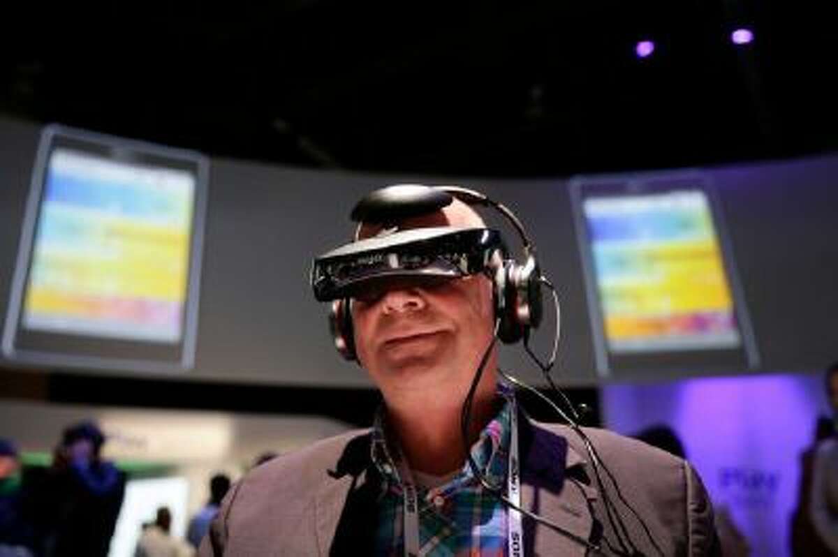 Juergen Boyny, of Germany, watches a video clip with a personal viewing device at the Sony booth at the International Consumer Electronics Show(CES) on Thursday, Jan. 9, 2014, in Las Vegas.