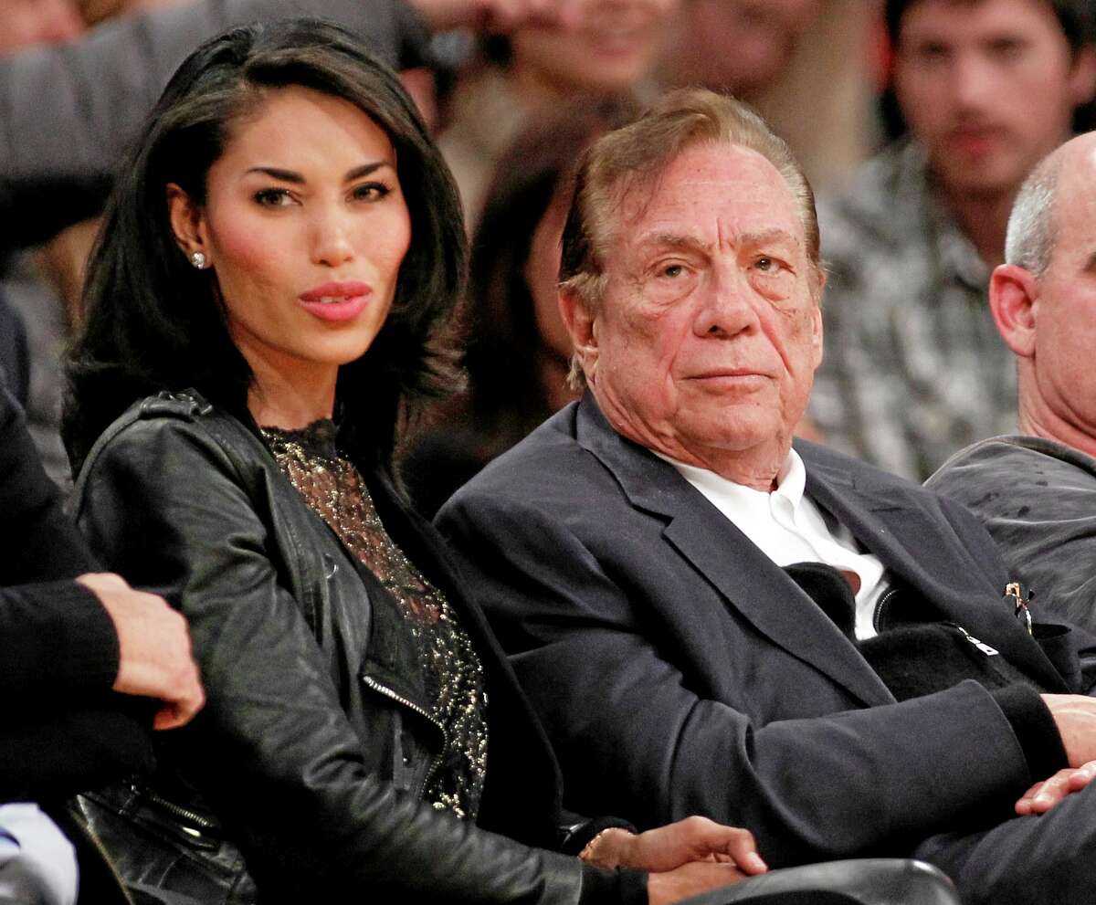 FILE - In this Dec. 19, 2010, file photo, Los Angeles Clippers owner Donald Sterling, third right, sits with V. Stiviano, left, as they watch the Clippers play the Los Angeles Lakers during an NBA preseason basketball game in Los Angeles. NBA commissioner Adam Silver announced Tuesday, April 29, 2014, that he is banning the owner for life from the Clippers organization over racist comments in recording. (AP Photo/Danny Moloshok, File)