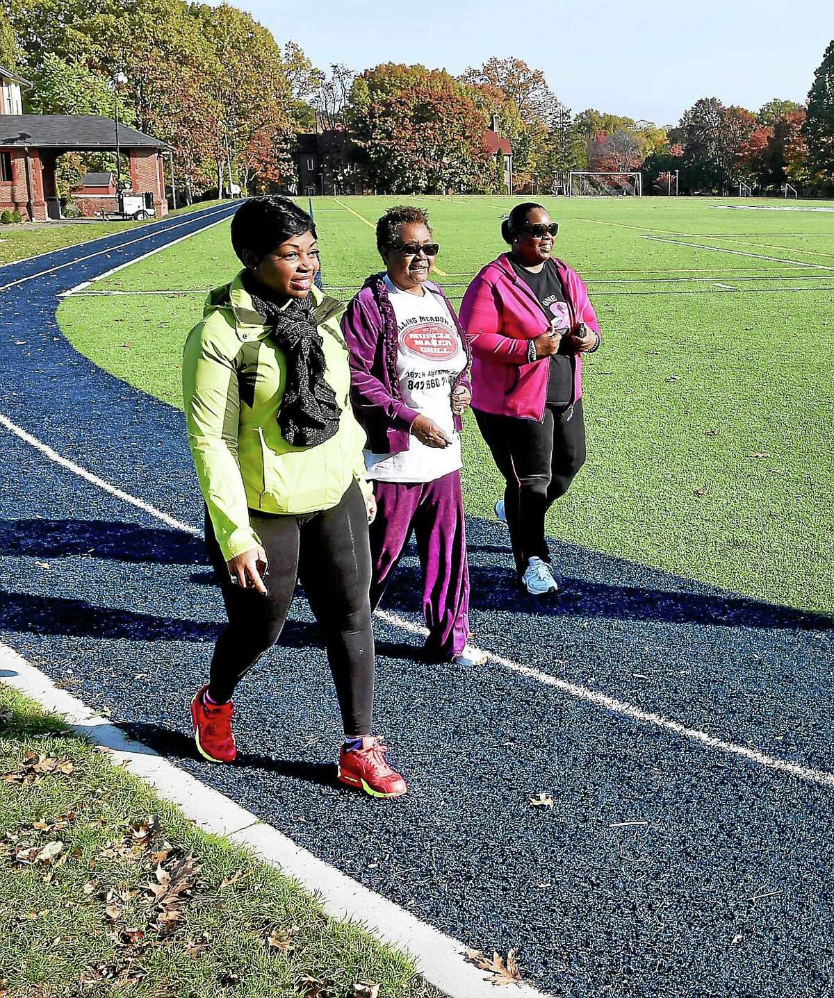 From left, Sherina Baker of the Community Resilience Team, Hazel Williams of the Pond Street block watch and Crystal Pittman of the Orchard Street block watch walk laps at the Albertus Magnus College track in New Haven Tuesday.