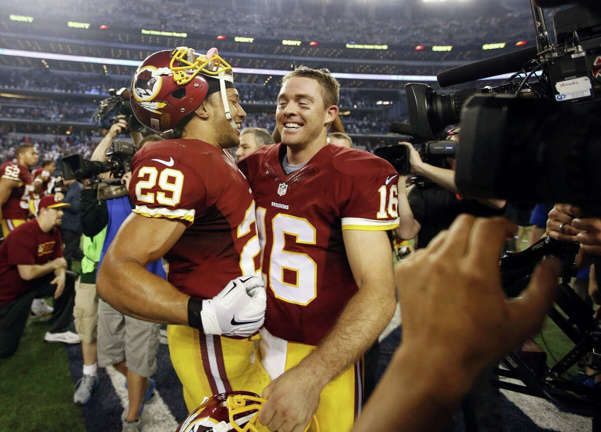 Washington’s Roy Helu (29) and quarterback Colt McCoy (16) celebrate after an NFL game against the Dallas Cowboys, Monday, Oct. 27, 2014, in Arlington, Texas. Washington won in overtime 20-17. (AP Photo/Tim Sharp)