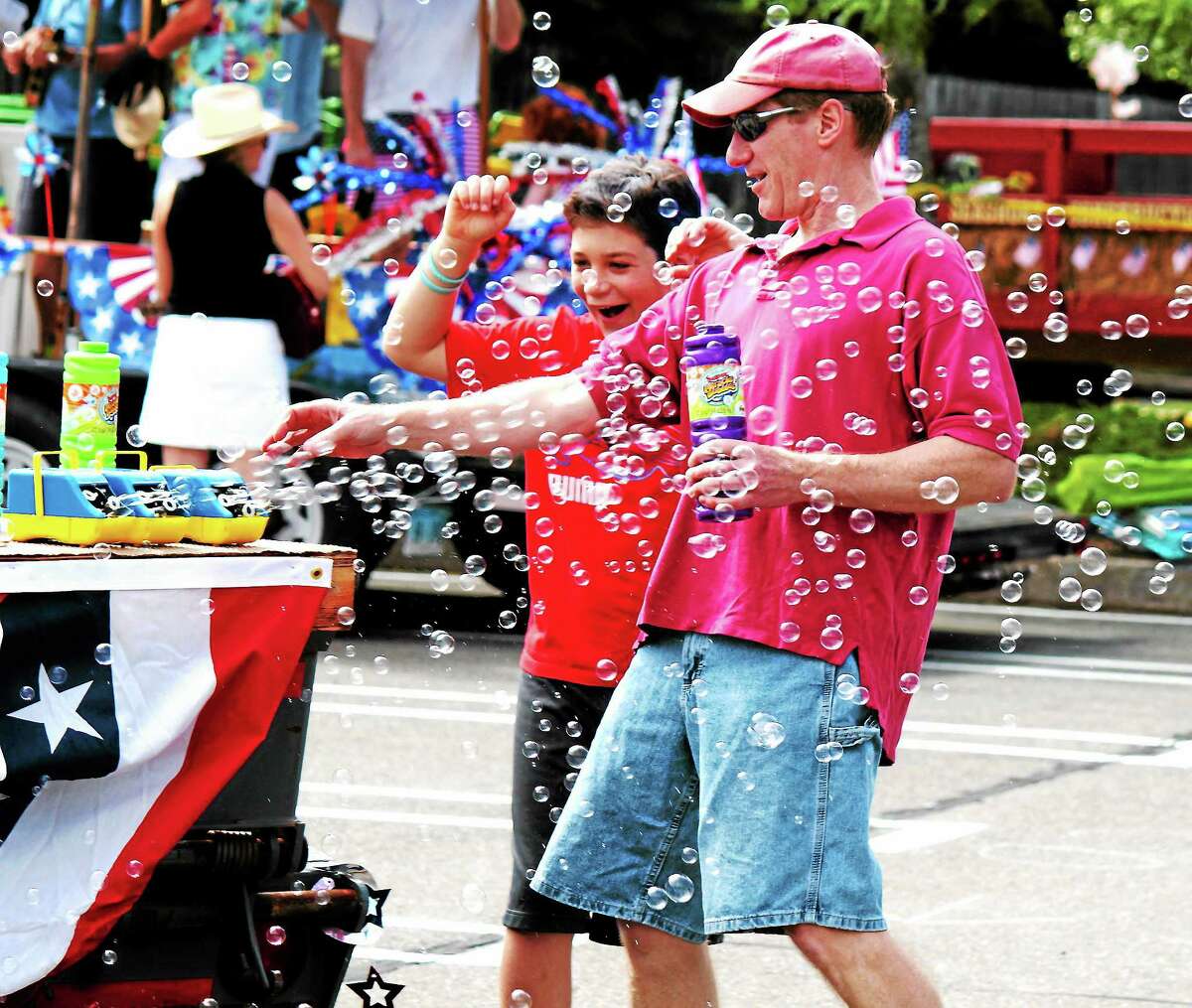 In this July 4, 2013, file photo, Dan Radka, left, and David Radka play with a bubble machine before Madison’s Fourth of July parade.