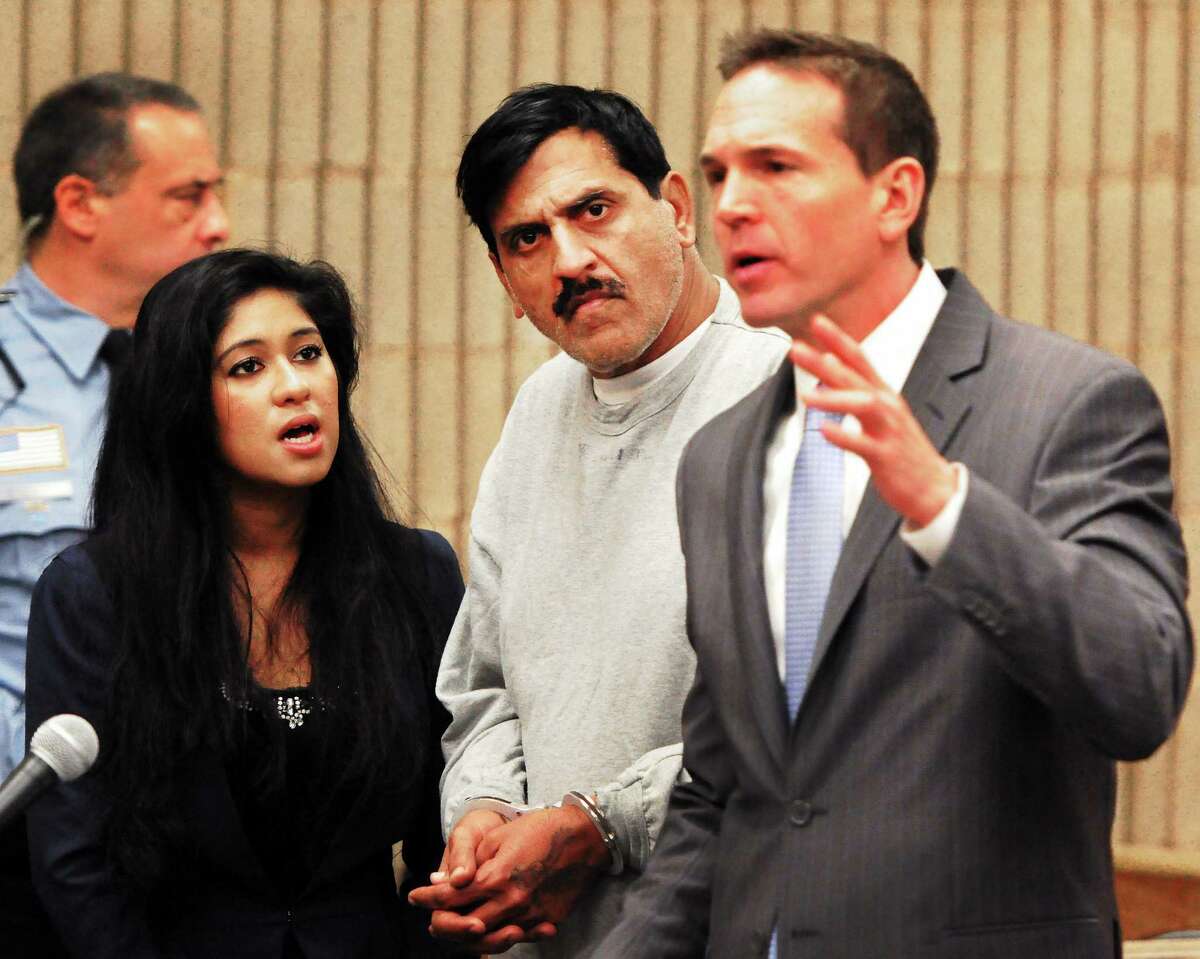 (Photo by Peter Hvizdak ó New Haven Register) ¬ Muhammad Chaudhry,41, of Milford, facing charges of first-degree assault and criminal attempt to commit first degree assault for attacking his estranged wife by throwing hot oil on her, center, appears at his arraignment with a court appointed interpreter,left, and Senior Public Defender Kenneth Bunker , right, Wednesday December 19, 2013 at Milford Superior Court.