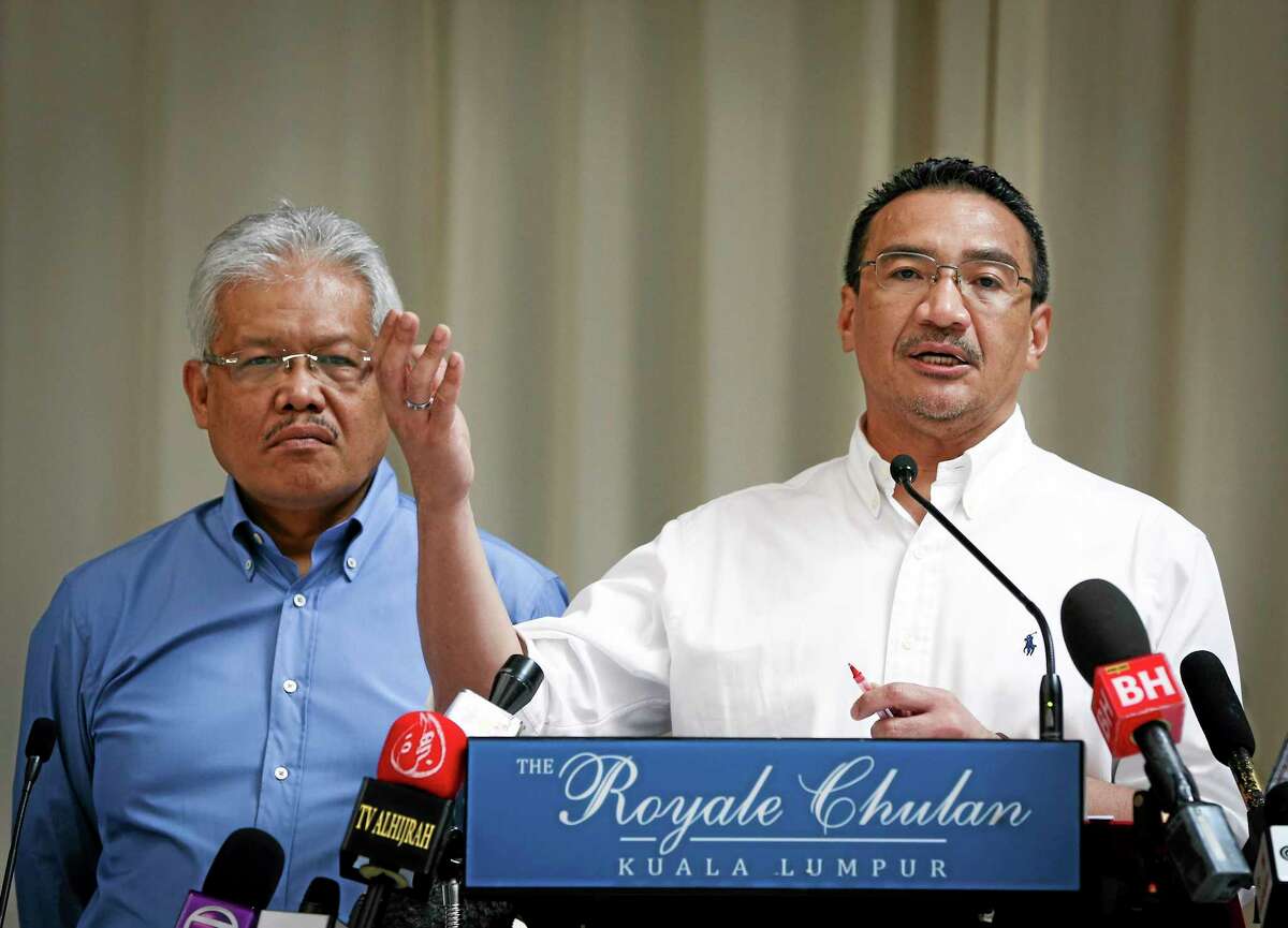 FILE- In this April 19, 2014 file photo, Malaysian Deputy Minister of Foreign Affairs Hamzah Zainudin, left, listens as Malaysia's acting Transport Minister Hishammuddin Hussein answers a question from a journalist during a press conference on the missing Malaysia Airlines Flight 370 at a hotel in Kuala Lumpur, Malaysia. Air traffic controllers did not realize that Malaysia Airlines Flight 370 was missing until 17 minutes after it disappeared from civilian radar, according to the preliminary report on the plane's disappearance released Thursday, May 1, 2014, by Malaysia's government. (AP Photo/Vincent Thian, File)