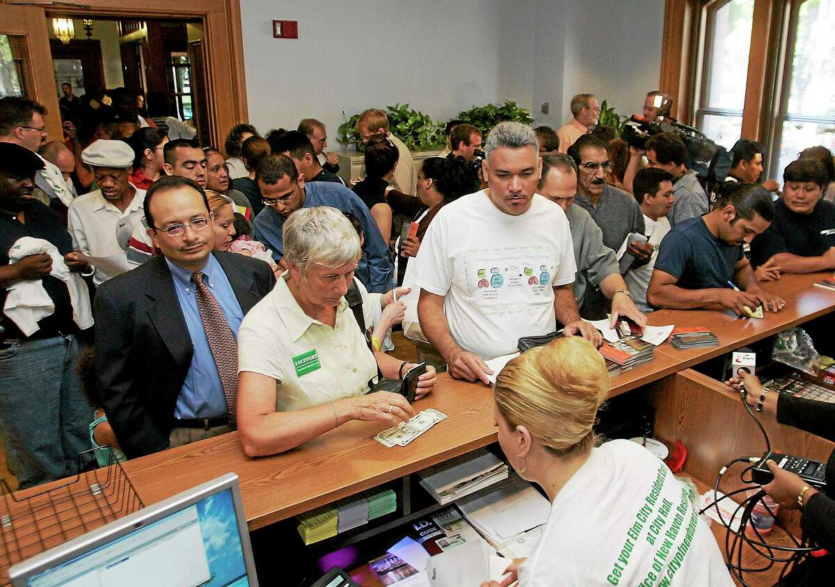 In this July 24, 2007 photo, applicants for the Municipal ID card crowd the ID card office in City Hall in New Haven, Conn. on the first day city residents could apply for the card.
