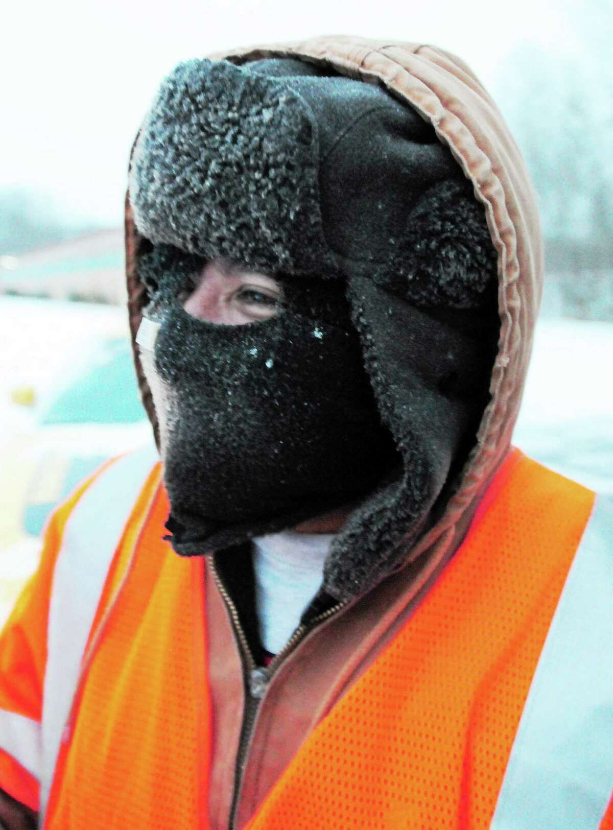 (Photo by Peter Hvizdak ó New Haven Register) An employees for DeMars Landscaping of Branford faces the cold with warm head gear as he shovels snow in a shopping plaza at 365 East Main Street Friday morning, January 3, 2014 .