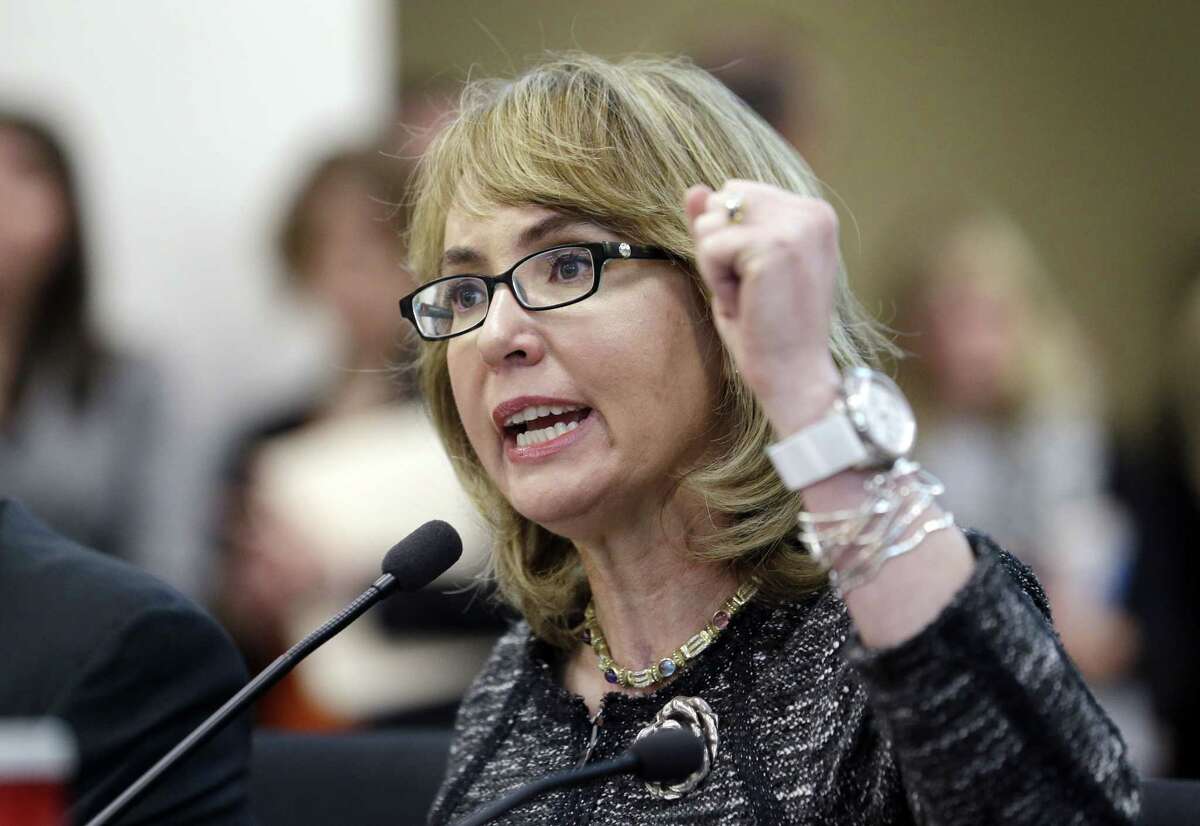 In this Jan. 28, 2014, file photo, former Arizona Congresswoman Gabrielle Giffords pumps her fist as she testifies before a Washington state House panel in Olympia, Wash. Giffords will begin a nine-state tour in Maine on Tuesday, Oct. 14, 2014, where she will advocate for tougher gun laws that she says will help protect women and families. Giffords, who was severely wounded by a gunman in 2011, will seek to elevate the issue of gun violence against women and push for state and federal action to make it more difficult for domestic abusers to get a hold of firearms.