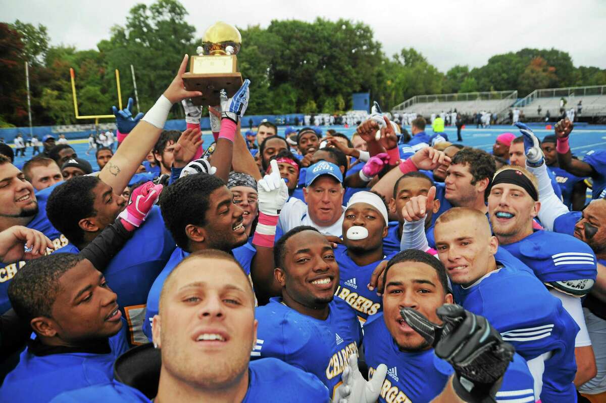 Members of the University of New Haven football team hold up the Elm City Trophy after defeating Southern Connecticut State 27-14 on Saturday at DellaCamera Stadium in West Haven.