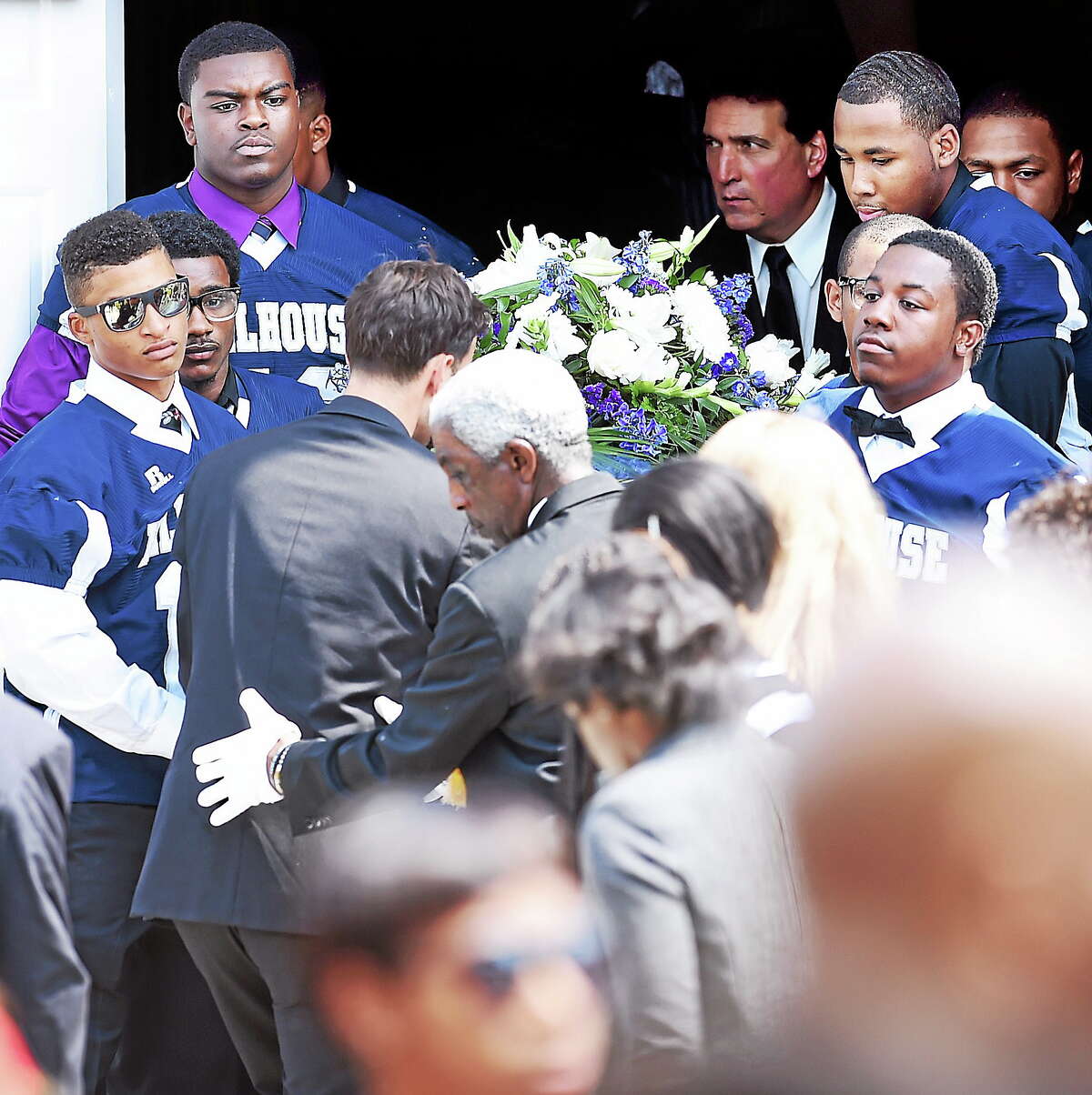 Members of the Hillhouse High School football team carry the casket of Jacob Craggett out of the Christian Tabernacle Baptist Church in Hamden on August 16, 2014.