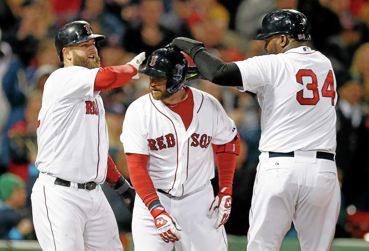Boston Red Sox's David Ortiz (34) and Mike Napoli, left, celebrate after scoring a on a three-run home run by Jonny Gomes, center, in the sixth inning of a baseball game against the Baltimore Orioles in Boston, Sunday, April 20, 2014. (AP Photo/Michael Dwyer)