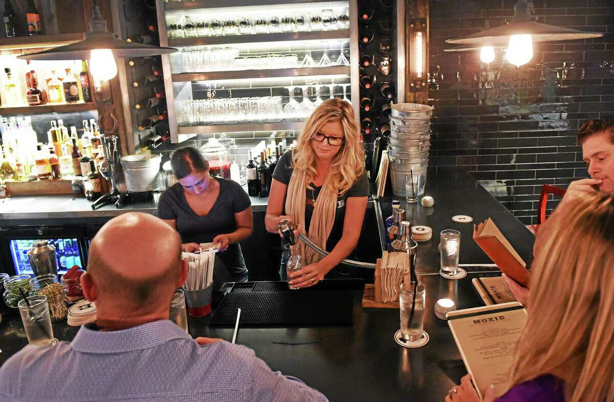 Helen Blanchard, far right, and bartender Jaimee Blanchard, serve customers at the new Moxie Restaurant on Wall Street in Madison during a soft opening Tuesday evening.