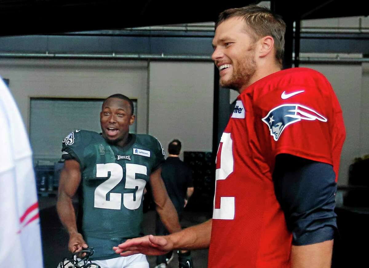 New England Patriots quarterback Tom Brady, right, and Philadelphia Eagles running back LeSean McCoy (25) chat after a joint training camp practice Wednesday in Foxborough, Mass.