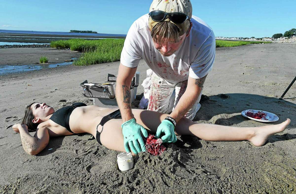 Special effects make-up artist Skippy Adams of Wallingford makes model Nicolette Vincelli of Milford look like a shark attack victim at Fort Trumbull Beach in Milford Thursday.