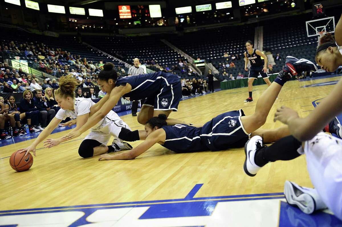 From left, Vanderbilt’s Jasmine Jenkins and UConn’s Gabby Williams and Kiah Stokes dive for a loose ball during a Nov. 28 game in Estero, Fla.