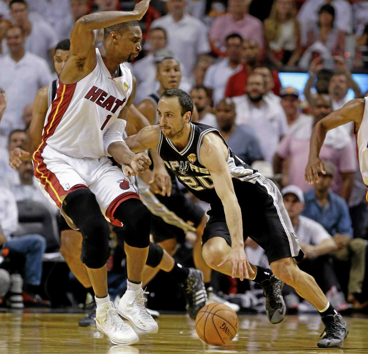 San Antonio Spurs guard Manu Ginobili (20) dribbles past Miami Heat center Chris Bosh (1) during the second half in Game 4 of the NBA Finals.