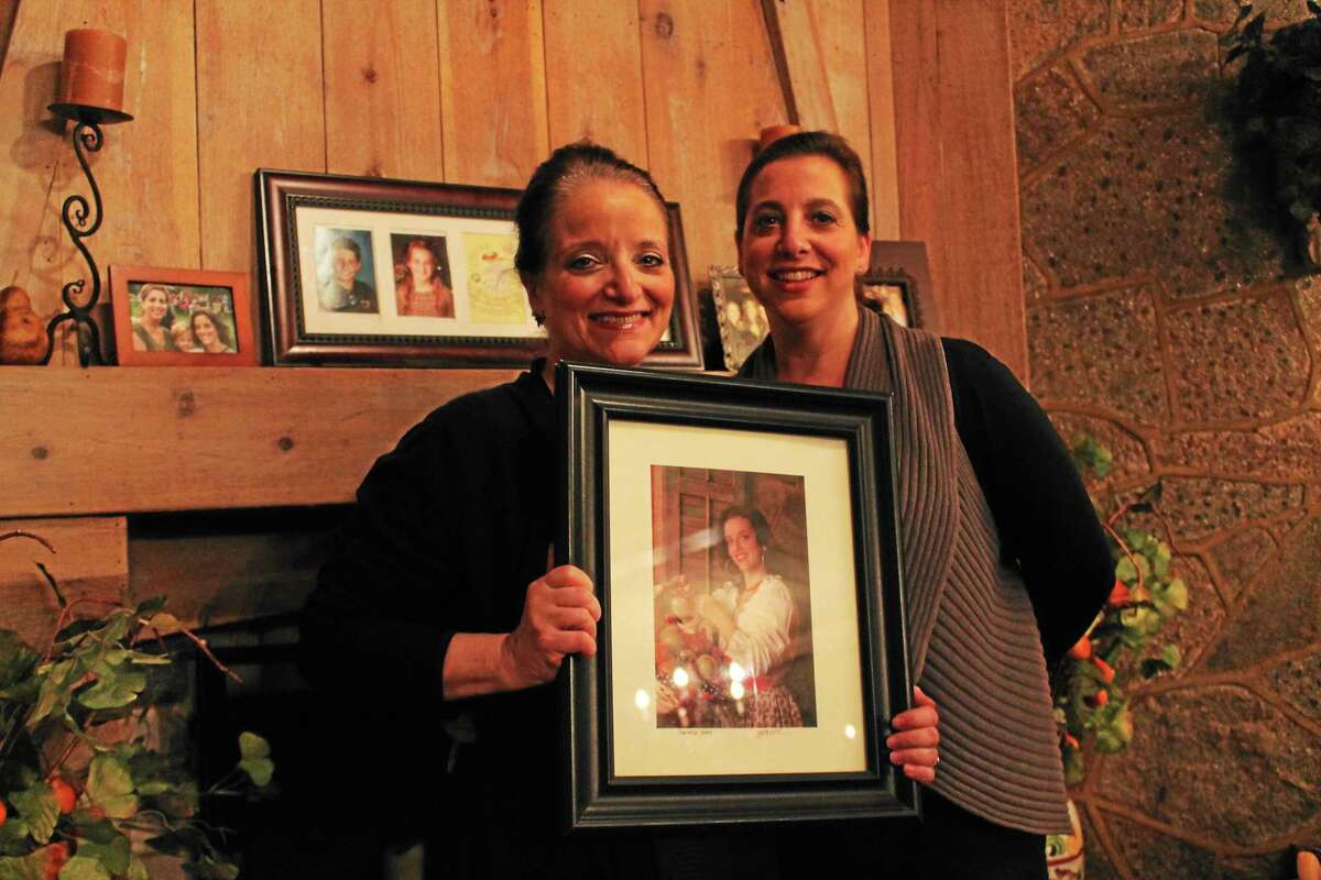 Antonio’s restaurant owner Gena Colavolpe, left, and daughter Andrea Finta, right, say the time is right to move on. In Colavolpe’s hands is a portrait of her other daughter, Gina, the restaurant’s master chef.