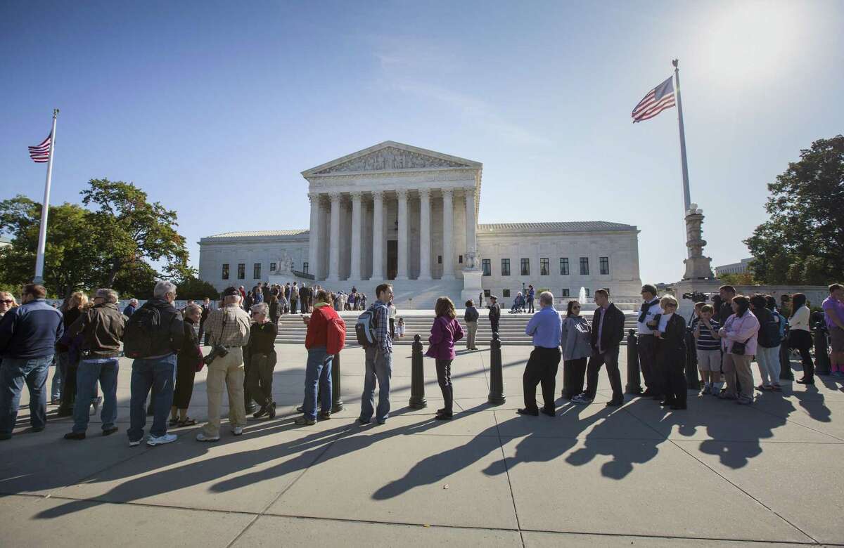 People wait to enter the Supreme Court in Washington, Monday, Oct. 6, 2014, as it begins its new term.