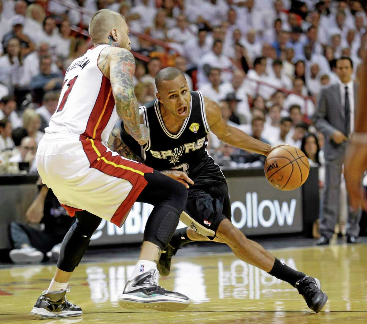 San Antonio Spurs guard Patty Mills (8) drives around Miami Heat forward Chris Andersen (11) in the second half of Tuesday’s game.