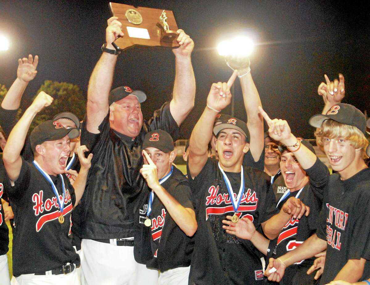 Branford baseball coach George Dummar raises the Class L state championship plaque after the Hornets defeated Berlin for the title in 2009. Dummar succumbed to cancer last Sunday. As Register sports columnist Chip Malafronte points out, Dummar was the link to 100 years of Branford baseball history. Frank “Beauty” McGowan debuted with the Branford High varsity team in 1914. When McGowan was 79, he was a scout with the Orioles and signed Dummar in 1980. Dummar eventually coached Mike Olt, who clubbed 12 homers as a rookie this year for the Chicago Cubs.