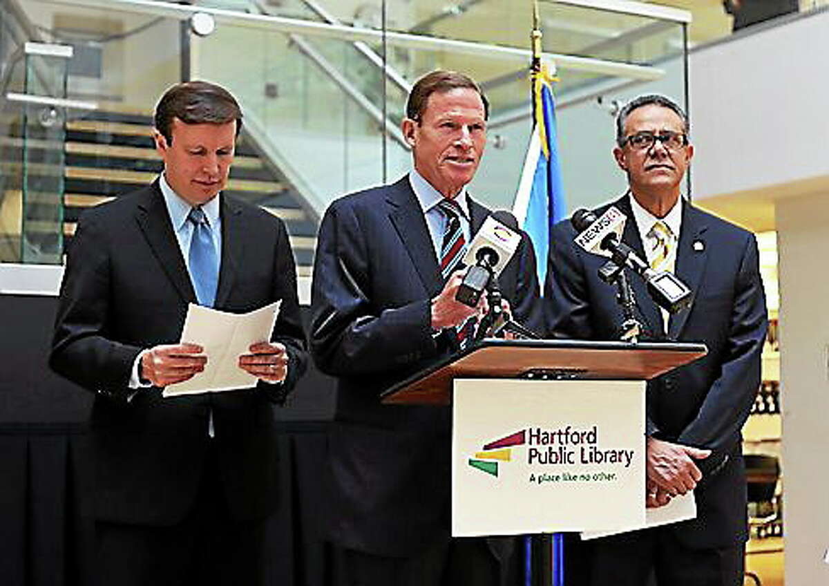 U.S. Sens. Chris Murphy, left, and Richard Blumenthal speak at a press conference Monday. Galo Rodriguez, president and CEO of the Village for Families and Children, is at right.