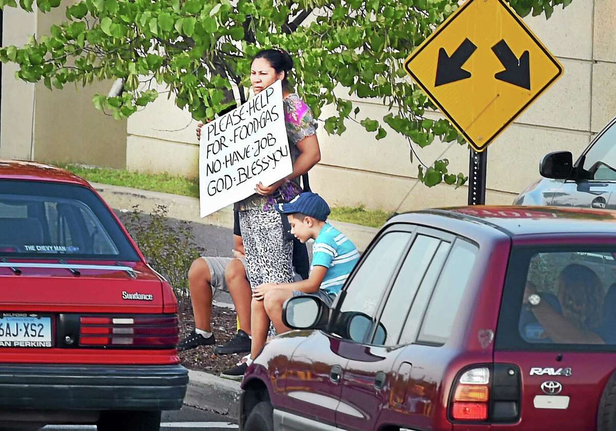 A woman stands with a sign off the Posat Road in Milford recently.
