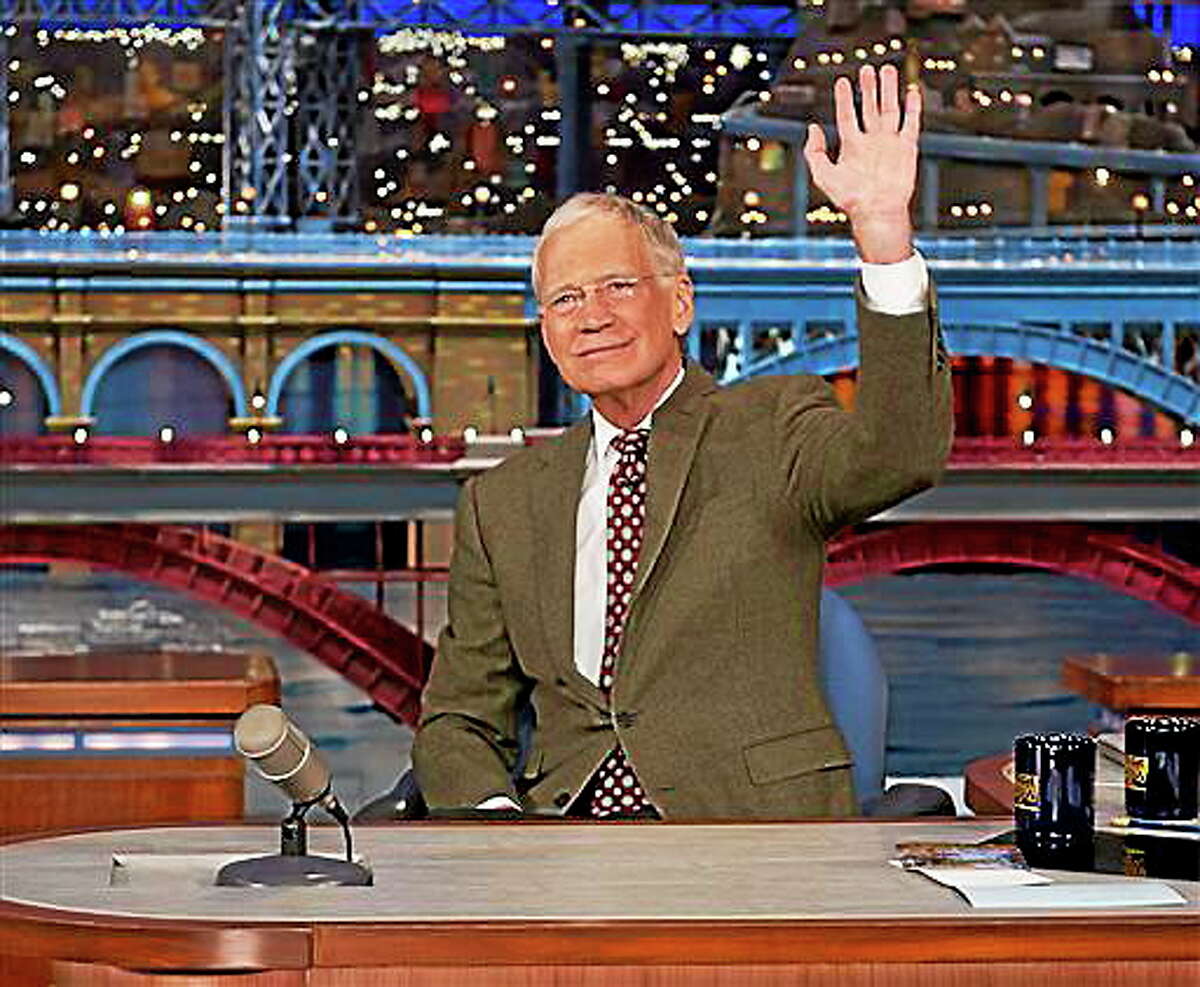 In this photo provided by CBS, David Letterman, host of the Late Show with David Letterman, waves to the audience in New York on Thursday, April 3, 2014, after announcing that he will retire sometime in 2015. Letterman, who turns 67 next week, has the longest tenure of any late-night talk show host in U.S. television history, already marking 32 years since he created “Late Night” at NBC in 1982.