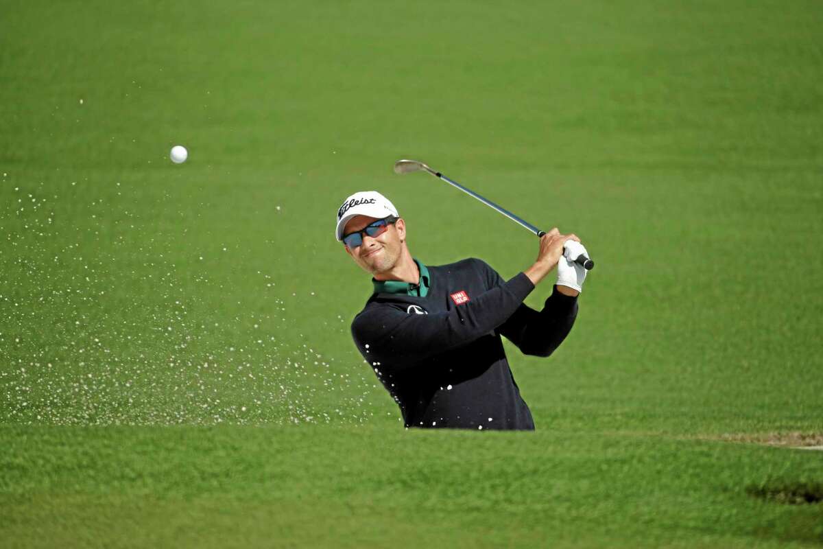 Adam Scott hits out of a bunker on the second fairway during the first round of the Masters Thursday.